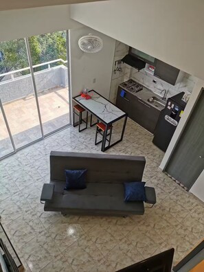 A modern living space with a sofa, dining table, and kitchen area. - Apartamento Confortable. Edimar 301 (Magdalena)
