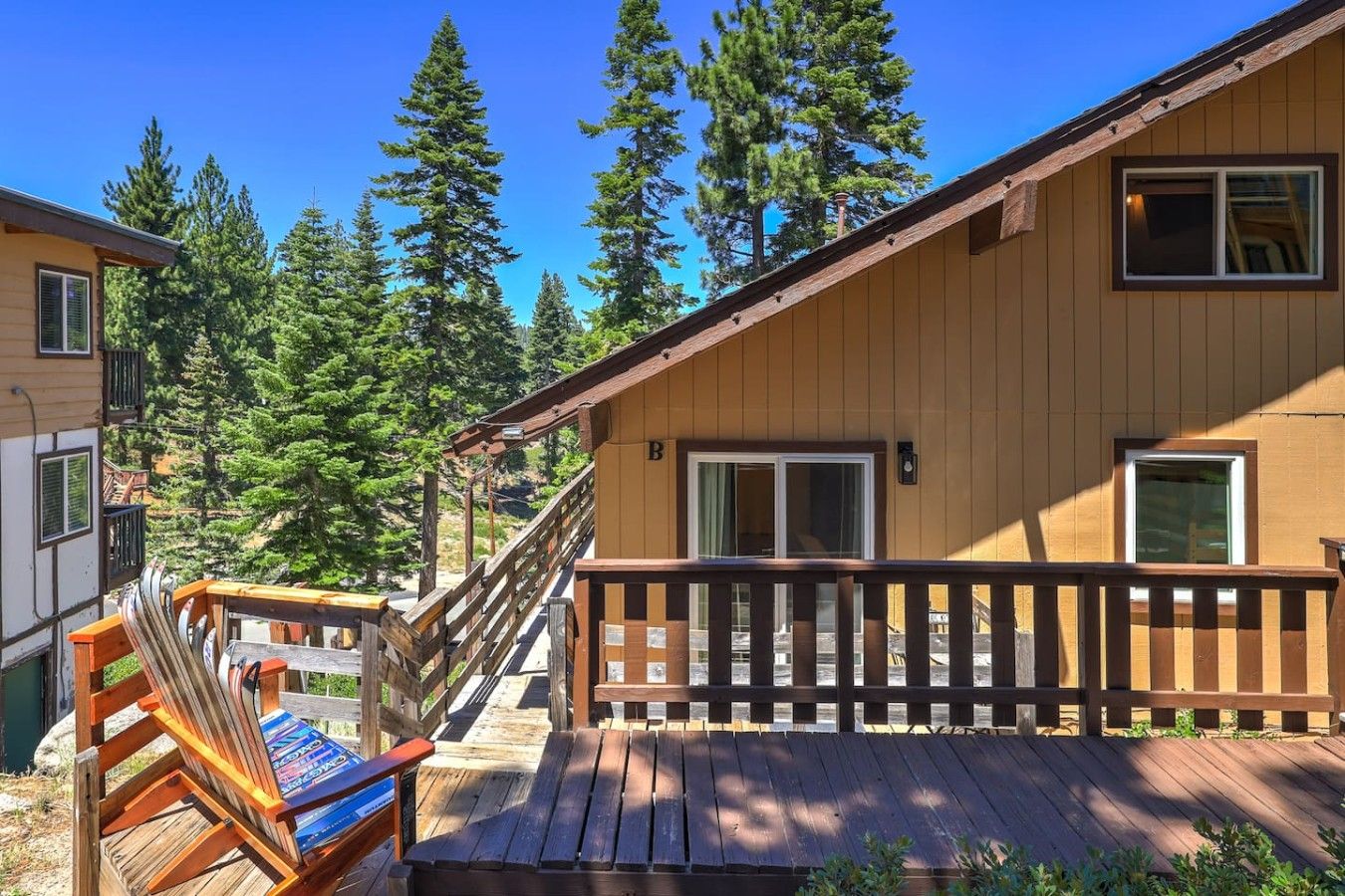 A wooden cabin with a deck, a staircase, and a window.