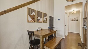A dining area with a wooden table, black chairs, and a bench. There are decorative wall panels above the table. - Cozy Alpine Retreat | BBQ, Views + Fireplace (Stateline)