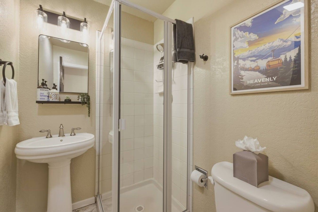 A bathroom with a shower, sink, and toilet.