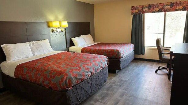 Una habitación de hotel con dos camas, un escritorio y una silla.