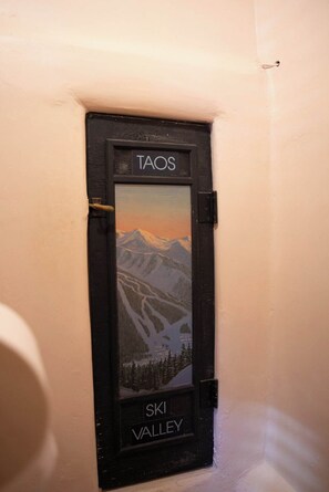 A door with a black frame and a scenic view of mountains and a valley. - Art Filled Adobe Casita, where the mountains and the desert meet. (Taos)