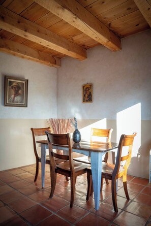 Zona de dinar amb caires de fusta, una taula i un vas.