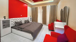 Quarto moderno com cama, mesas de cabeceira, escrivaninha e uma cadeira.