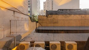 A rooftop with air conditioning units and a metal fence. - VNM - VN Vila Olimpia by Anora Spaces (São Paulo)