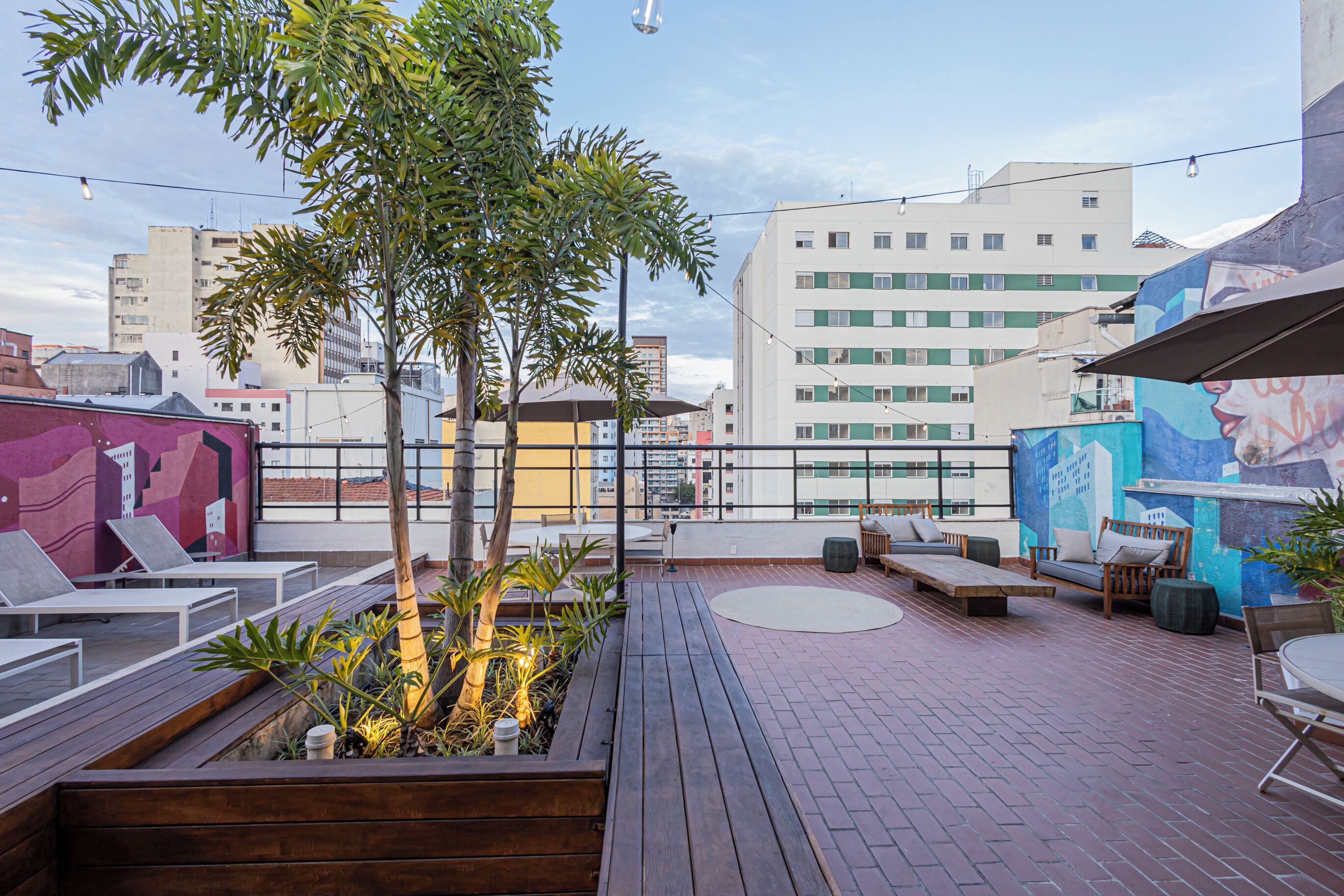 An outdoor patio area with seating, a wooden deck, and a view of the cityscape.