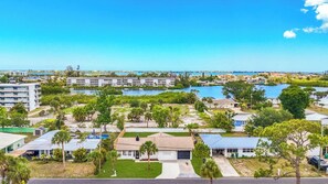 Une zone résidentielle côtière comprenant plusieurs immeubles, une marina et un ciel d’un bleu éclatant.