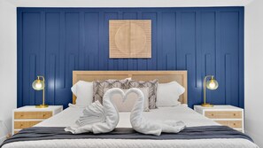 Un lit avec une tête de lit, deux tables de chevet et un luminaire fixé au mur.
