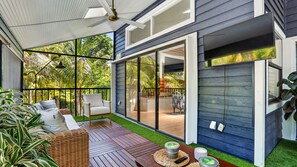 Une terrasse extérieure moderne avec une plateforme en bois, une chaise blanche et une table en osier.