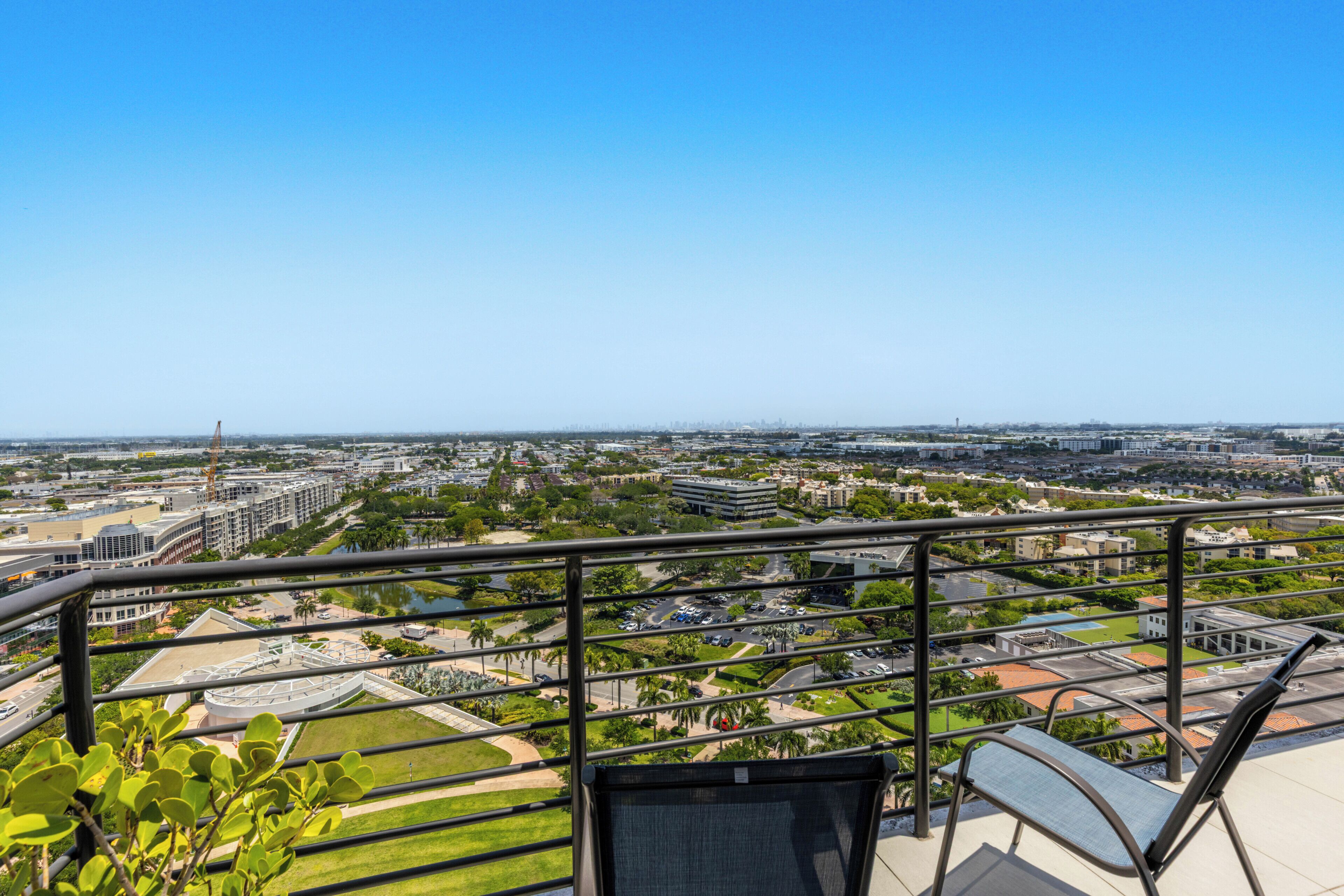 Ein Balkon mit Blick auf eine Stadtlandschaft, einschließlich Gebäude und Grünflächen.