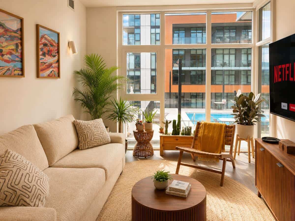 Un salon moderne avec un canapé, un fauteuil, une table basse et un téléviseur diffusant Netflix.