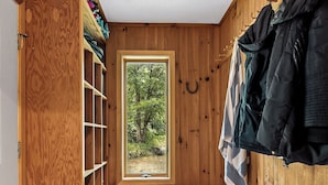 Un interno in legno con una finestra, scaffali e una panca.