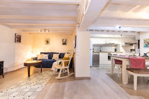 Ein Wohnzimmer mit einer Couch, einem Schaukelstuhl, einem Couchtisch und einem gemusterten Teppich.