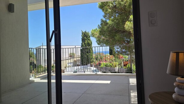 Un balcone con vista sulla strada, un corrimano e una lampada su un tavolino.