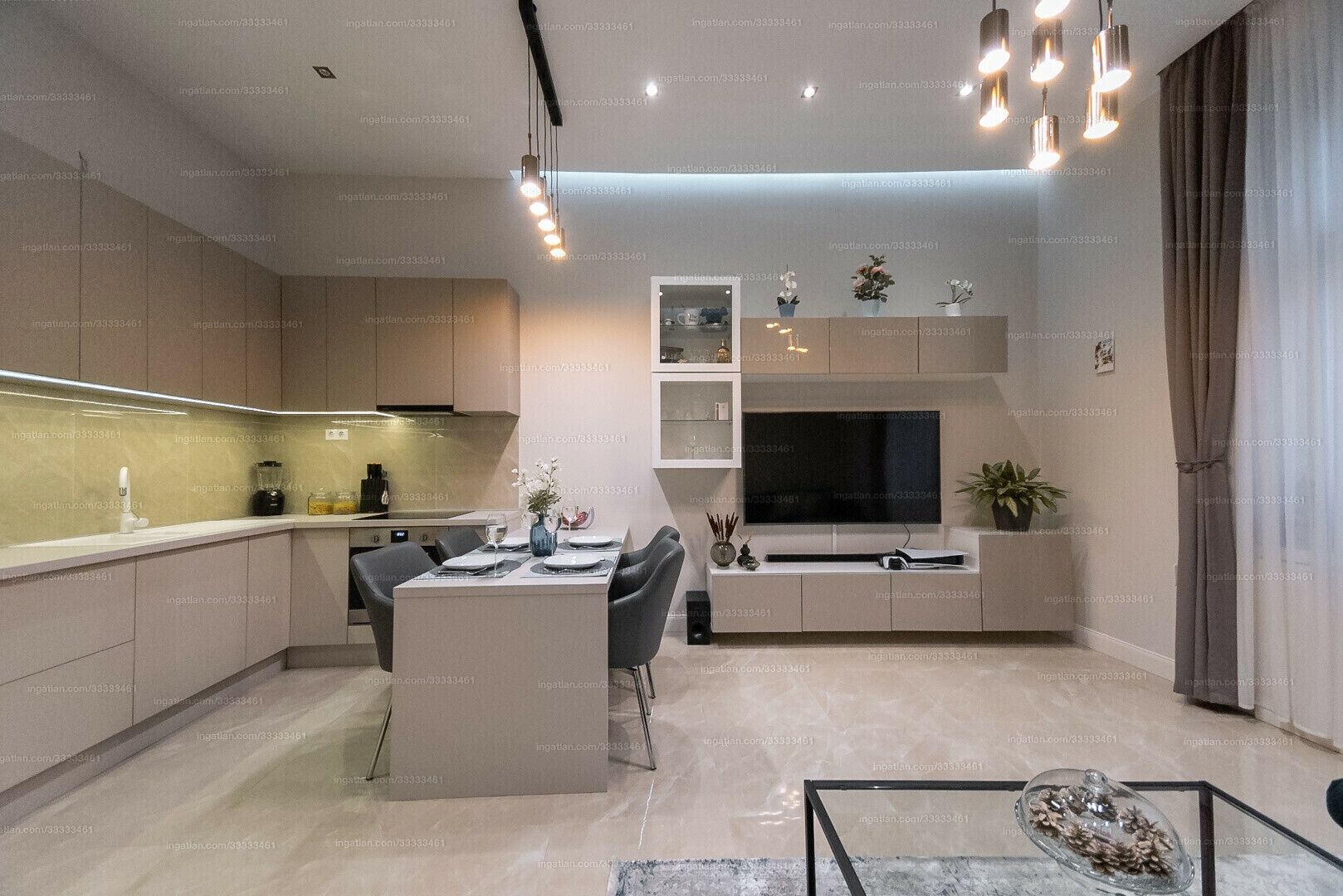 A modern kitchen with a dining area, built-in TV, and pendant lighting.