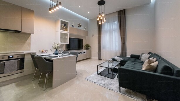 A modern kitchen with a central island, a dining area with a black sofa, and a living room with a large TV. - St Francis of Assisi Superior Budapest (Budapest)