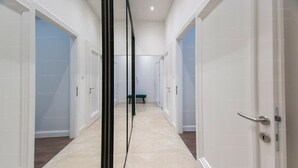 A corridor with white doors, a bench, and a tiled floor. - St Francis of Assisi Superior Budapest (Budapest)