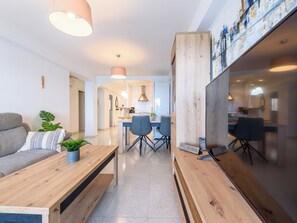 Ein modernes Wohnzimmer mit einer Couch, einem Holztisch und einem Essbereich mit Stühlen und Tisch.