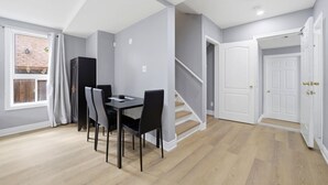 A modern apartment with a dining area, a staircase, and a door. - Private 1BR Apt | WiFi | Parking | Nr all Amenities (Mississauga)