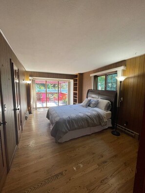 Ein Schlafzimmer mit Bett, Nachttisch, Lampe und Fenster.