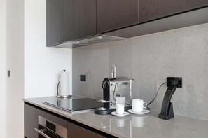 Una cocina moderna con cafetera automática, máquina de espresso y toma de corriente.