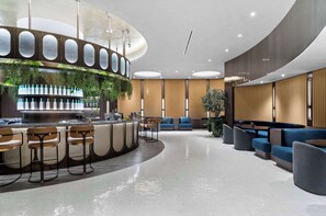 A modern lounge area with a curved bar, seating, and a ceiling with circular light fixtures. - Luxury E11EVEN 1BR Skyline Views & ELITE Amenities (Miami)