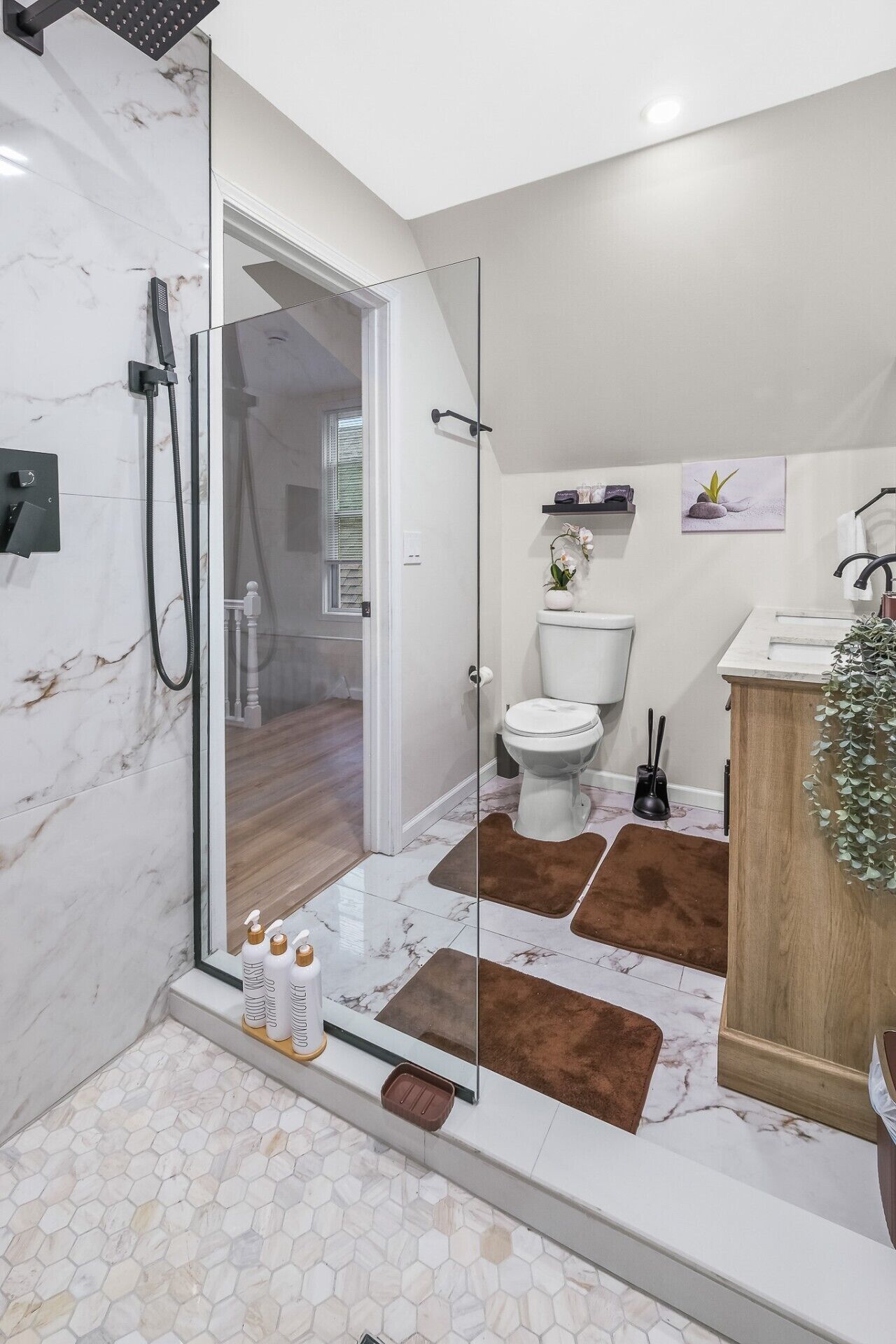 Une salle de bain moderne avec une douche à parois de verre, des toilettes et un lavabo.