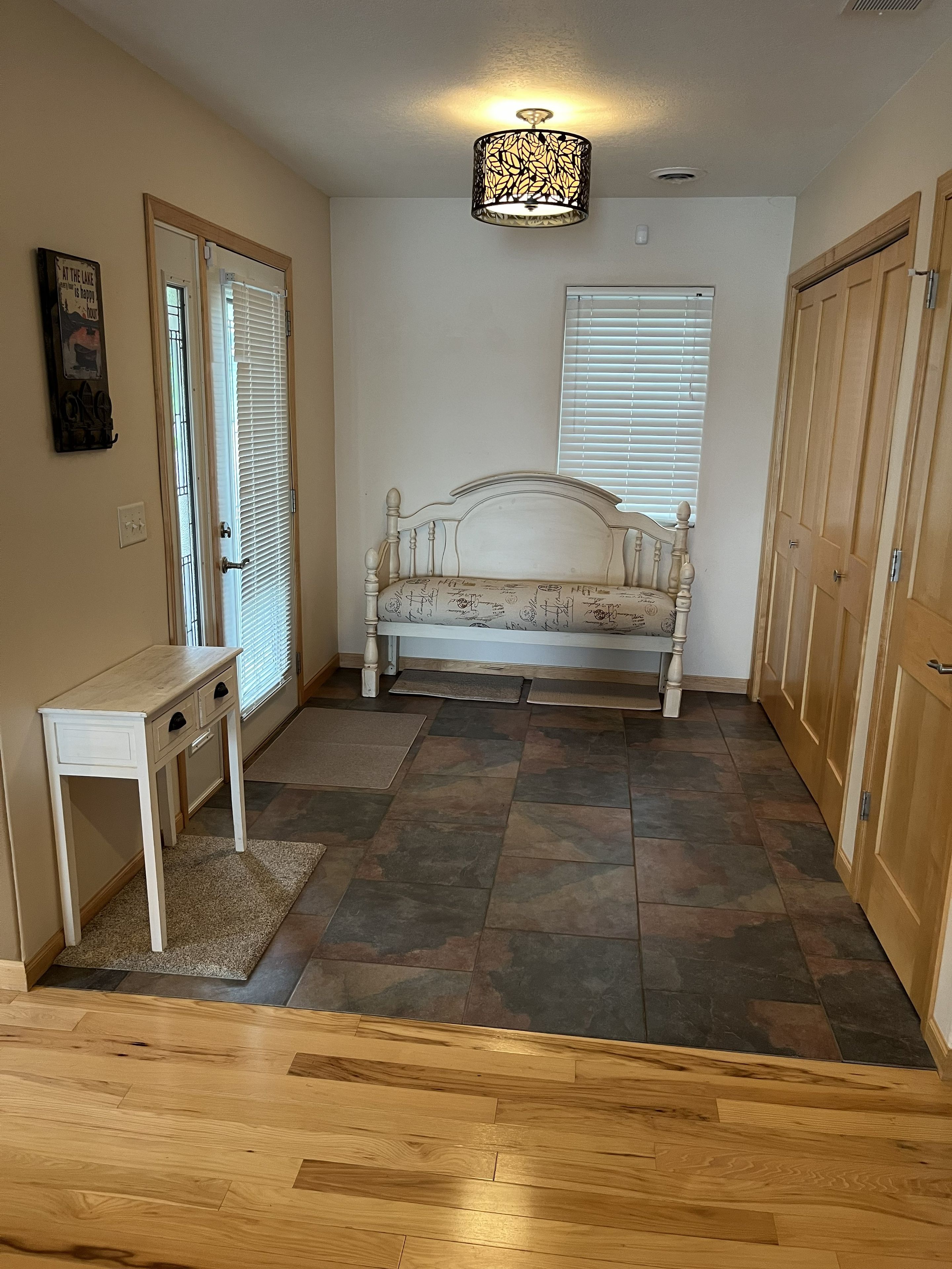 A room with a bed, a desk, a door, and a ceiling light fixture.