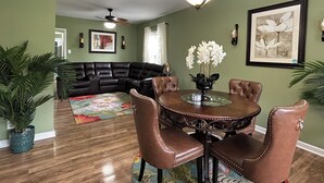 A dining area with a round table, leather chairs, a ceiling fan, and a floral rug. - Bright and Airy 3 BRM - 1 BATH -5 Mins to Falls (Niagara Falls)