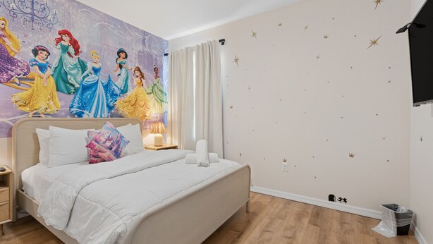 A bedroom with a large bed, a nightstand, a wall mural, and a starry wall decal. - 8BR Disney-Area Resort Home, Private Pool, Game Room | Sleeps 17,Lazy River-7054 (Davenport)