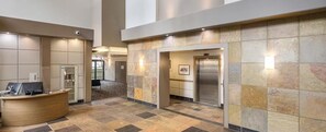 A reception area with a curved desk, a security camera, and a tiled wall. - Worldmark Luxury Suite Downtown Vancouver for World Cup Games. Avail 7/2 & 7/7 (Vancouver)