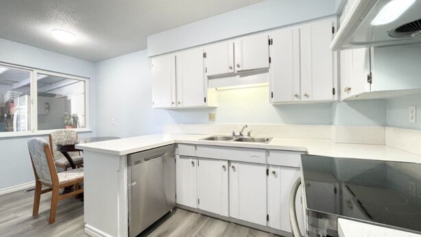 A modern kitchen with white cabinetry, a dishwasher, and a black stove. - Richmond Airport Cozy Holiday House with free shuttle (Richmond)