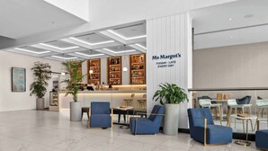 Um lobby moderno com balcão de recepção, área de estar e bar.