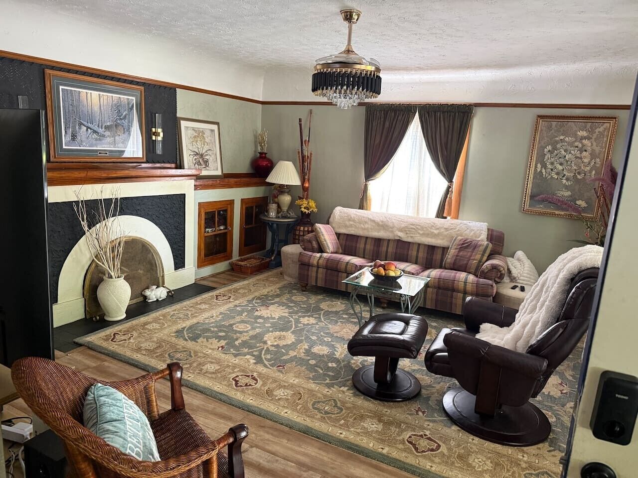 Ein Wohnzimmer mit Kamin, Sofa, Sessel und Massagesessel.