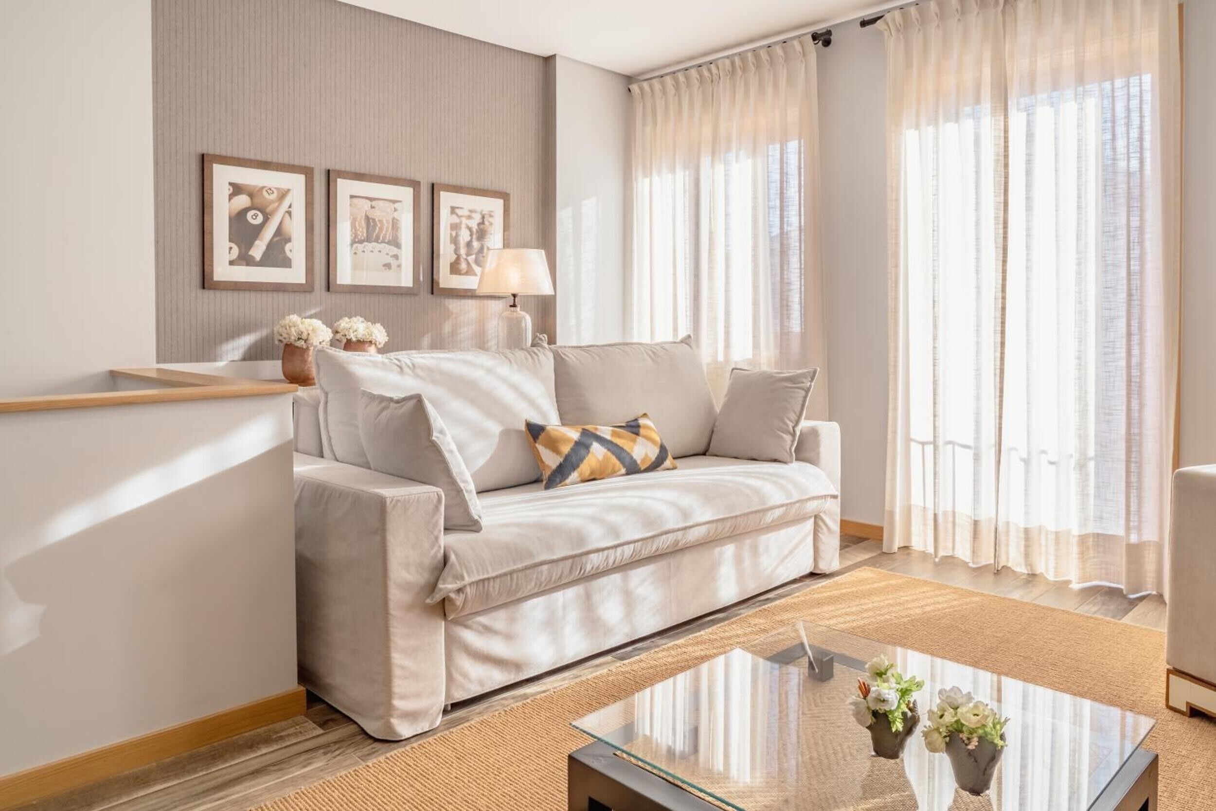 A modern living room with a sofa, a glass coffee table, and a lamp.