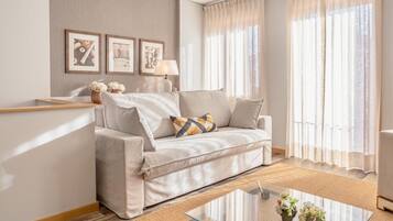 A modern living room with a sofa, a glass coffee table, and a lamp.