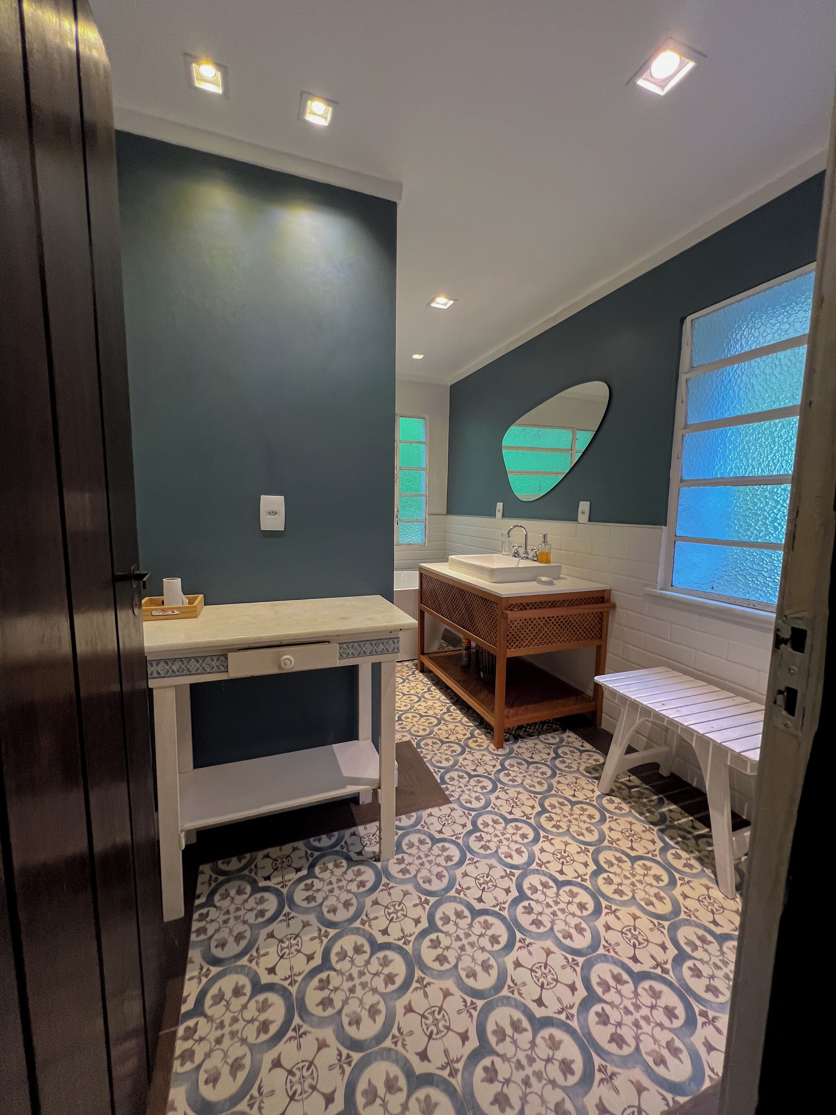 Une salle de bain avec un lavabo, un miroir et des carreaux de sol à motifs.