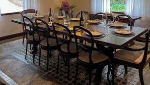 A dining area with a chandelier, dining table set for six, and chairs. - Villa Casa Blanca (Teresópolis)