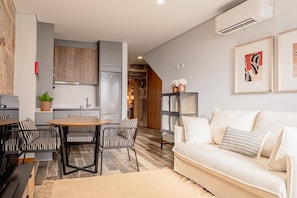 Ein modernes Wohnzimmer mit einer Couch, einem Esstisch und gestreiften Stühlen.