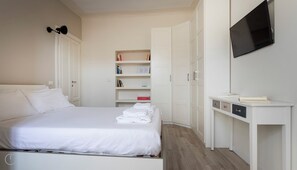 A hotel room with a bed, a desk, a TV, and a wardrobe. - Italianway - San Calocero 29 B (Milano)