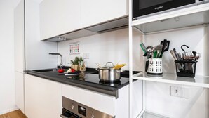 A modern kitchen with a black countertop, stainless steel appliances, and a pot of spaghetti. - Italianway Comfort - Boncompagni 3B (Milan)