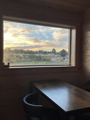 A room with a large window, a wooden table, and a chair. - Sundance Retreat: Private 5 Acres, 4BR +sleeping loft, 3 BA, hot tub, wood stove (Lafayette)