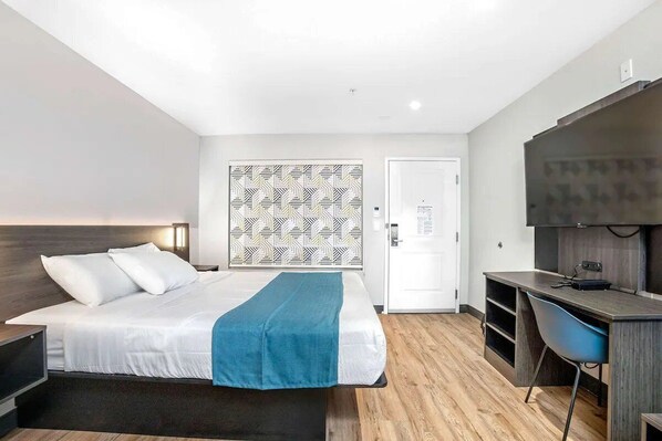 A modern hotel room with a bed, a desk, a chair, and a TV. - Explore Stockton’s Attractions from a Welcoming Retreat | Outdoor Pool Access (Stockton)