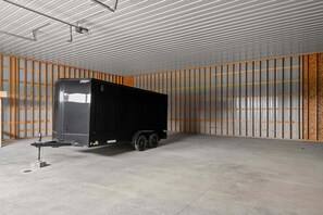 A black trailer in a warehouse with corrugated metal walls and a concrete floor. - Cozy 1-bedroom barn in lovely Seattle with AC (Seattle)