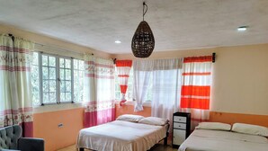 A bedroom with two beds, a chair, a cabinet, and a hanging light fixture. - el jardin de los anturios (Xico)