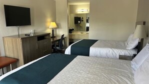 A hotel room with two beds, a desk, a chair, a TV, and a mirror. - 2 Accommodations 1.3 Mi from Reflection Riding Arboretum | Pets Allowed (Chattanooga)