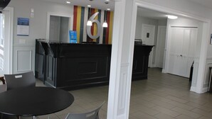 A reception area with a black counter, a large number '6' on the wall, and a door leading to a room. - 2 Accommodations 1.3 Mi from Reflection Riding Arboretum | Pets Allowed (Chattanooga)