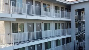 Ein mehrstöckiges Gebäude mit Balkonen, einem Pool und einer Treppe.