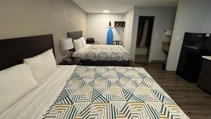 Une chambre d’hôtel avec un grand lit, un bureau, une chaise, une armoire et un téléviseur.