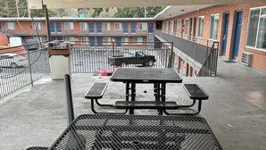 Une terrasse sur le toit, équipée d’une table de pique-nique et d’un barbecue en métal.